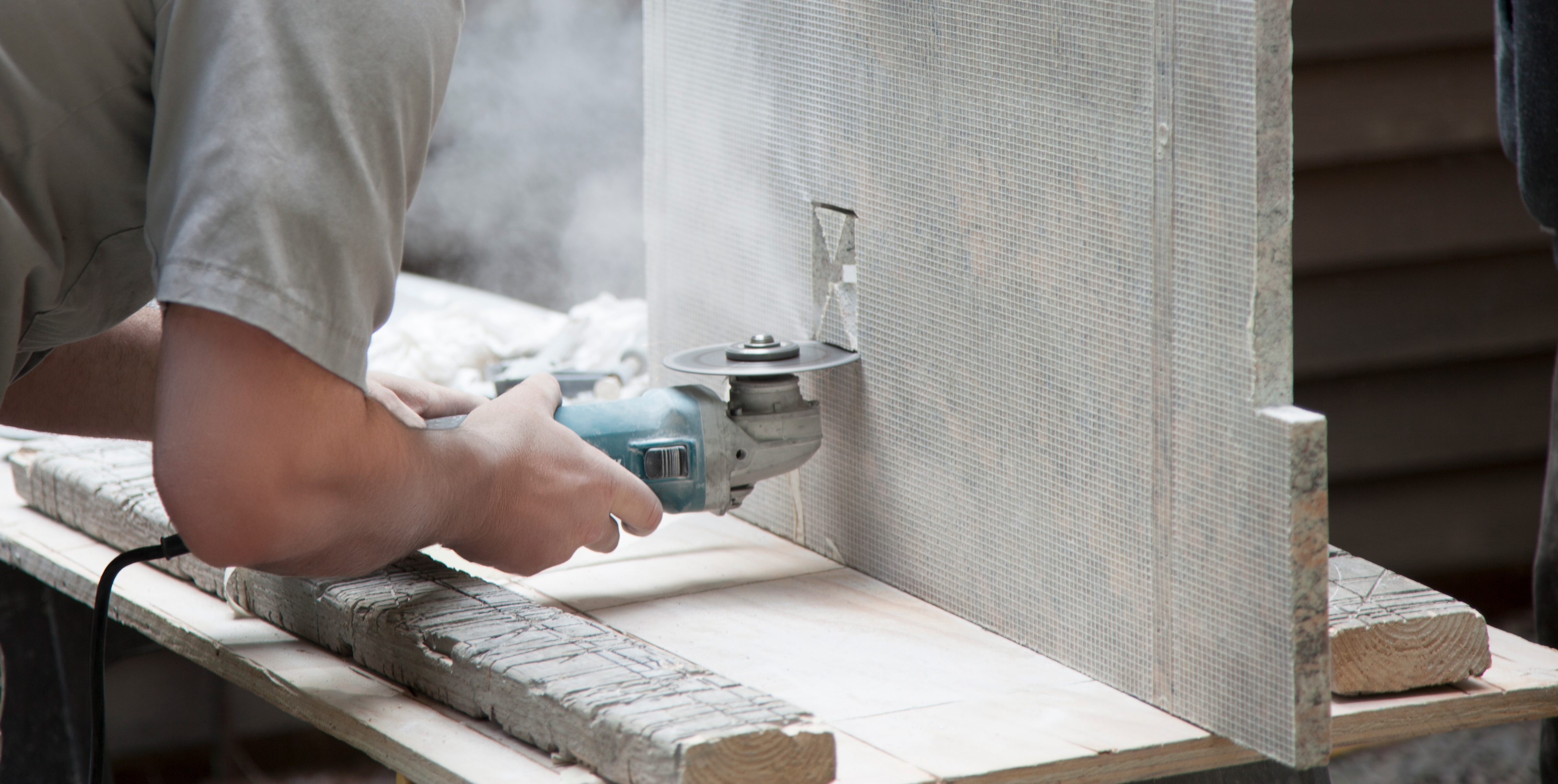 Man cutting stone countertop with a saw